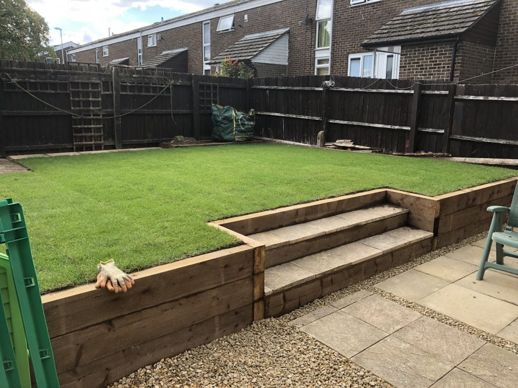 Raised lawn with a timber sleeper retaining wall and steps